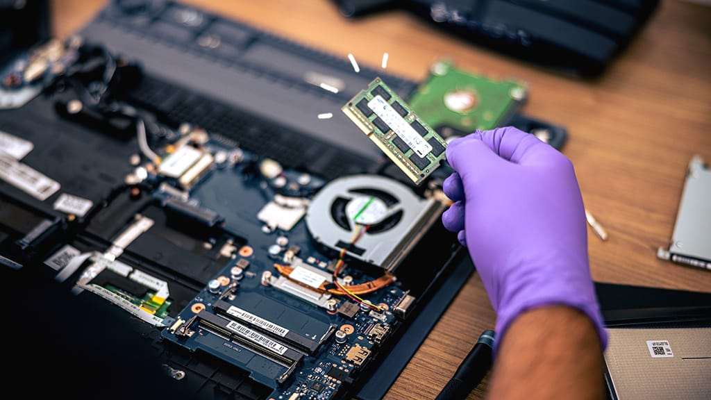 Gloved hand holding a laptop RAM stick